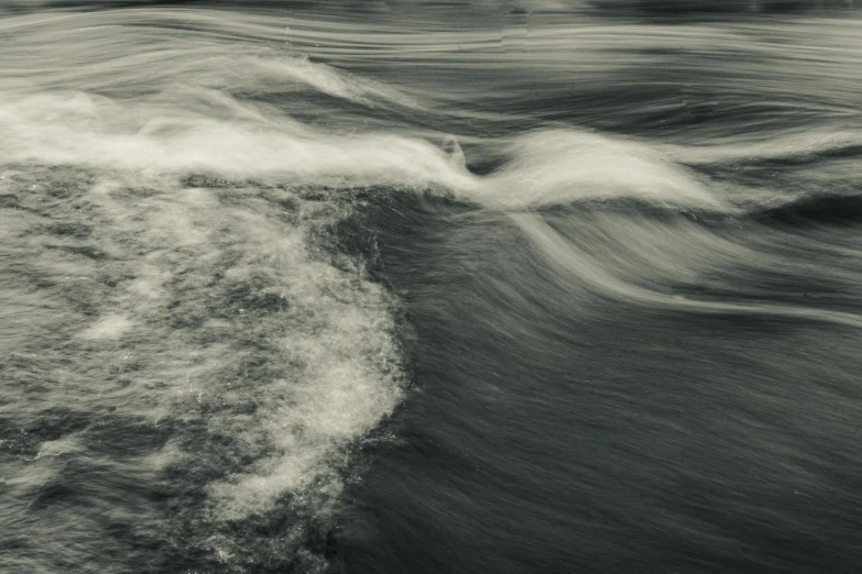 a wave breaking into shore with sky in background