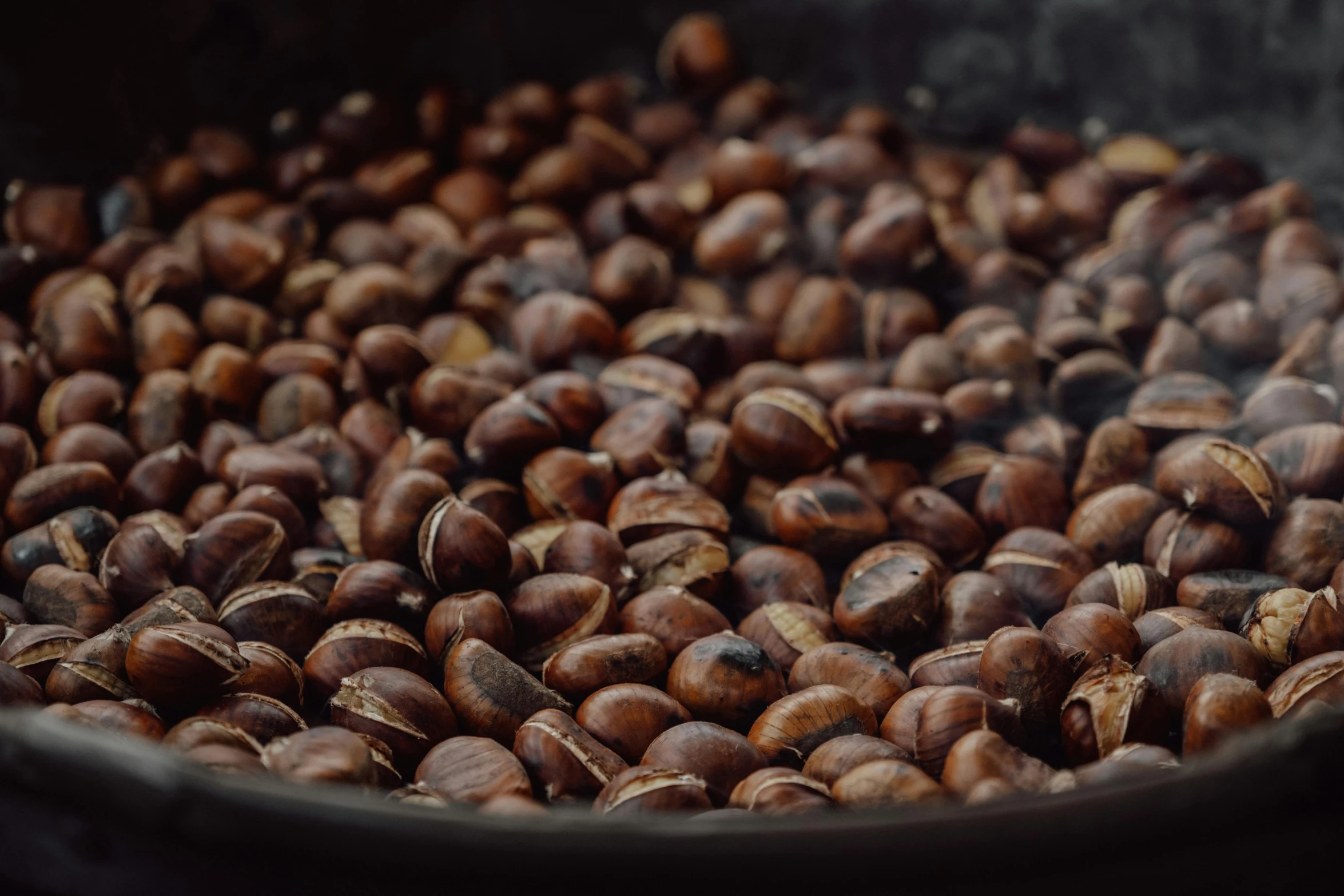 nuts are being cooked in a wok with a dark surface