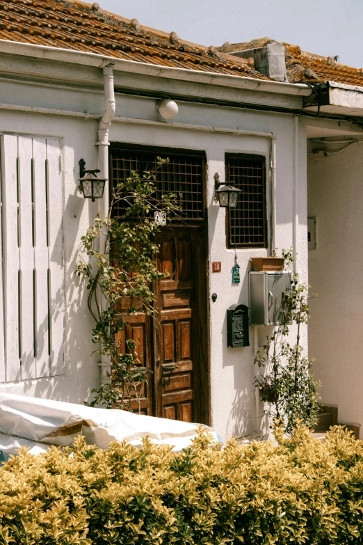 a small white home with wood doors and a brown window