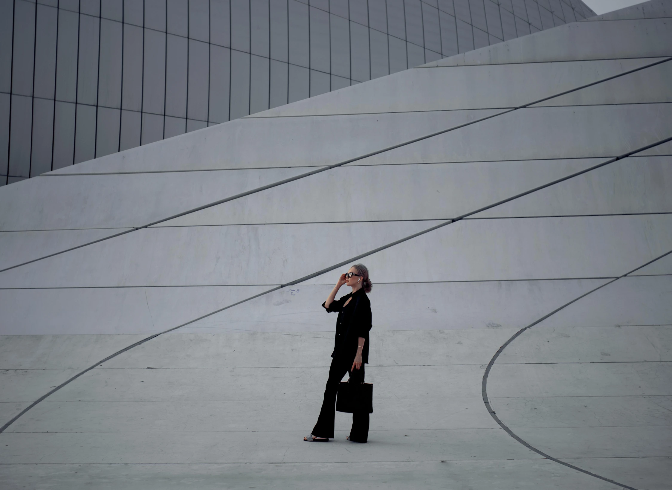 a woman with a suit and boot is talking on her cell phone