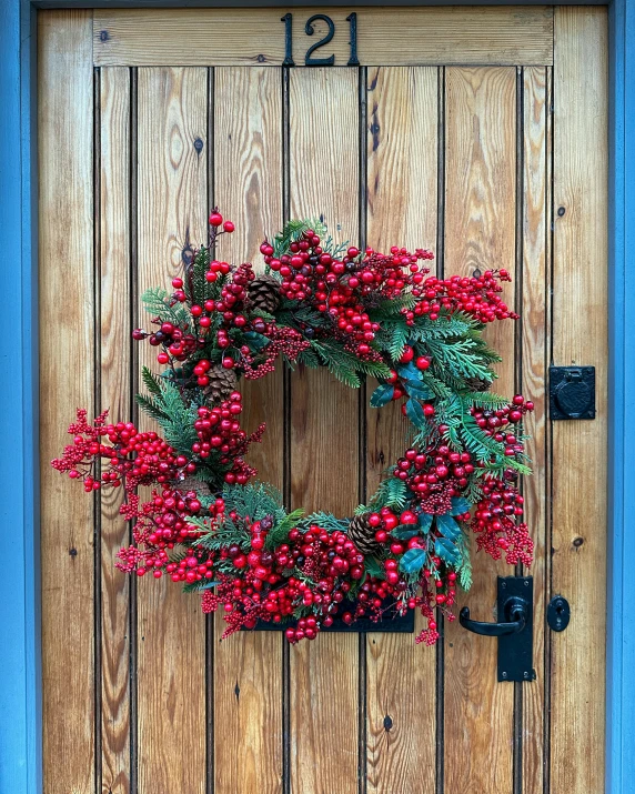 a wooden door decorated with a wreath and numbers