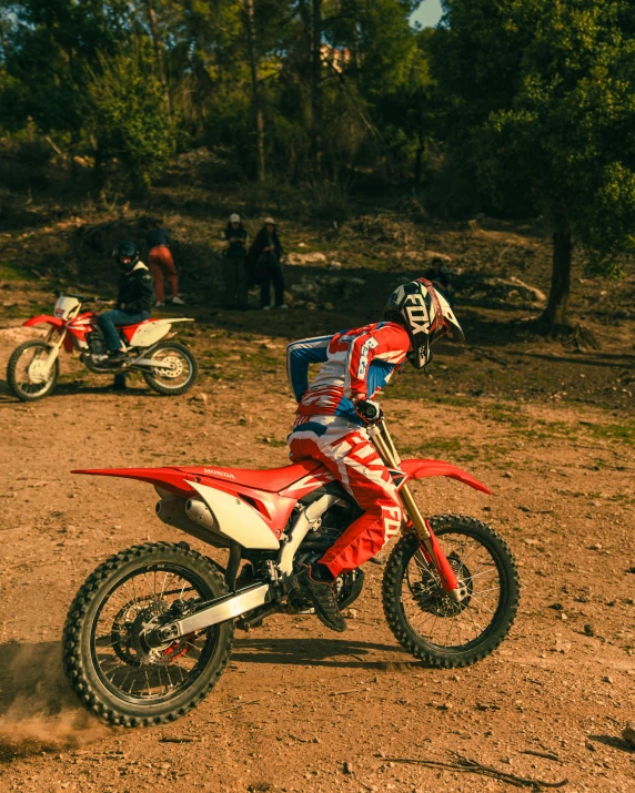 the two dirt bikes are parked on the dirt