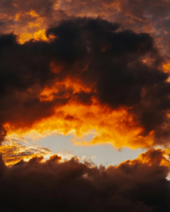 a jet plane flying in the air with orange and blue clouds