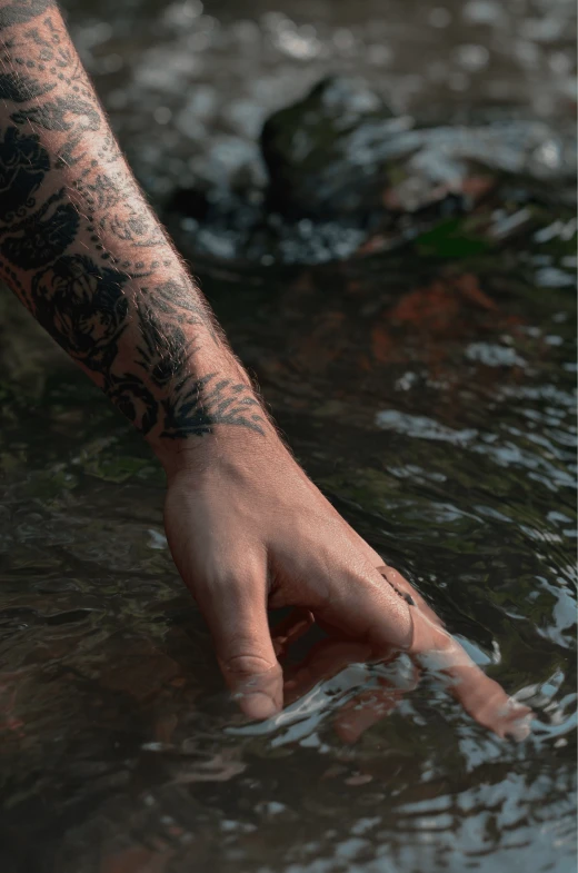 a person's hand reaching for soing in water