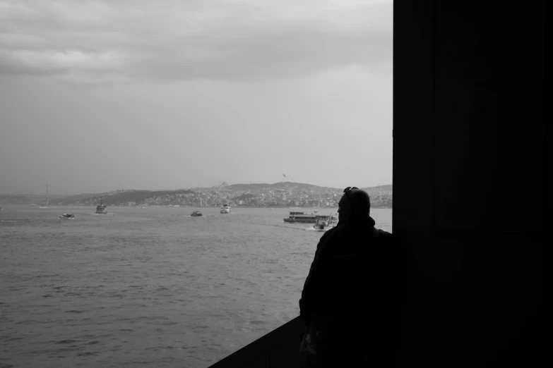 a person watching boats in the water from a deck