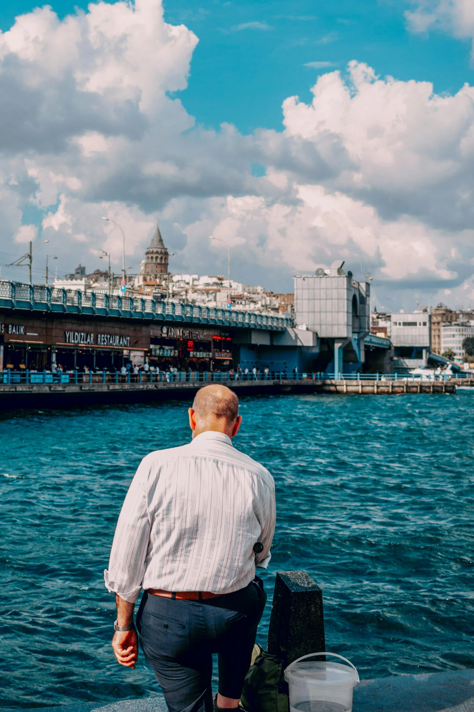 a man standing by the water looking back