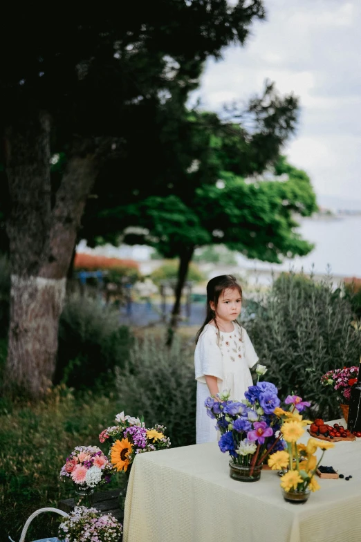 a  standing at a table in front of a tree