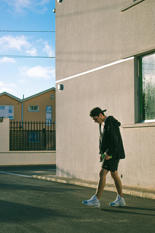 a man walks down a city street past a building