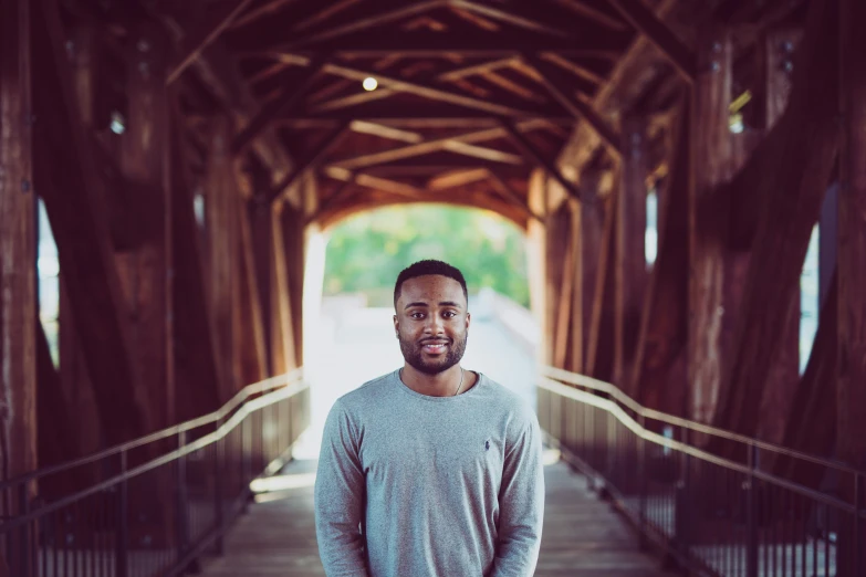 a man in grey shirt standing on bridge near walkway