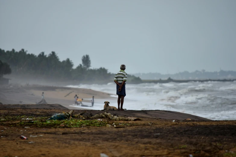 a man standing at the beach by the ocean