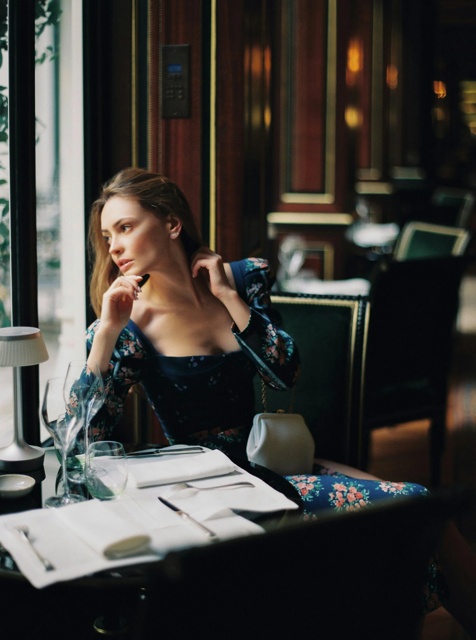 a woman sitting at a table in front of a window