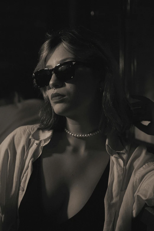 a black and white image of a woman with her sunglasses on