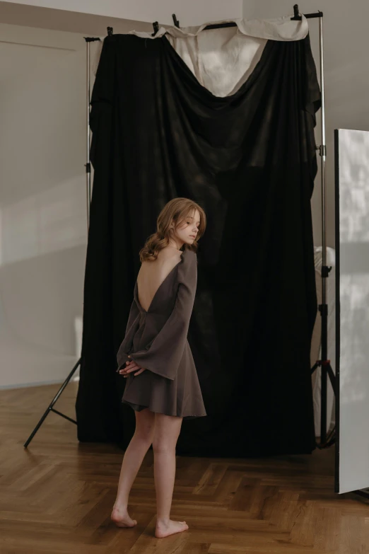 a woman poses while posing for a portrait in front of a studio backdrop