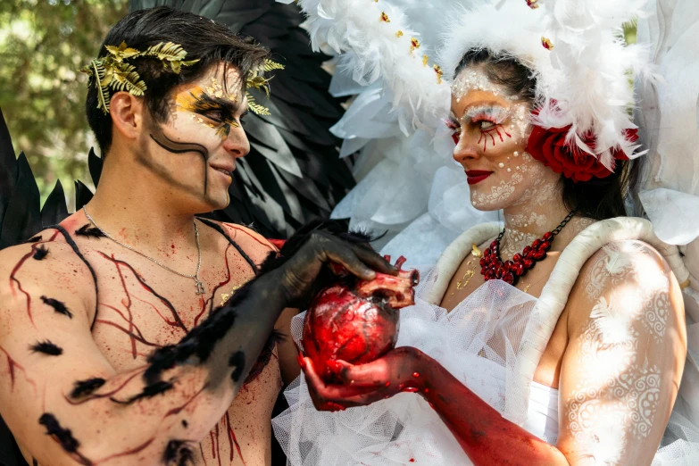 a man and woman dressed up with feathers on their bodies