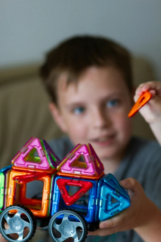 a little boy that is holding up some toys