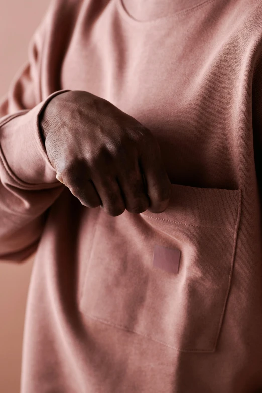 black man with a pink sweat shirt showing off his pocket