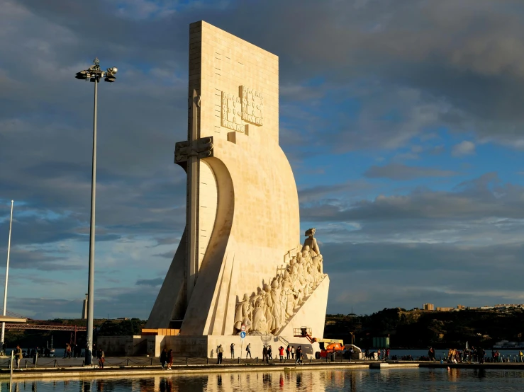 a large monument sits beside a body of water