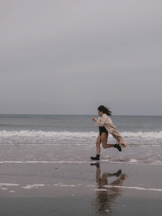 a woman running along the beach at twilight