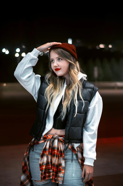 a woman posing with her hat and vest on