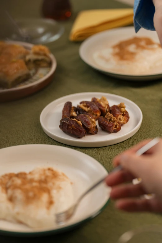 plates with various dishes of food are set on a table