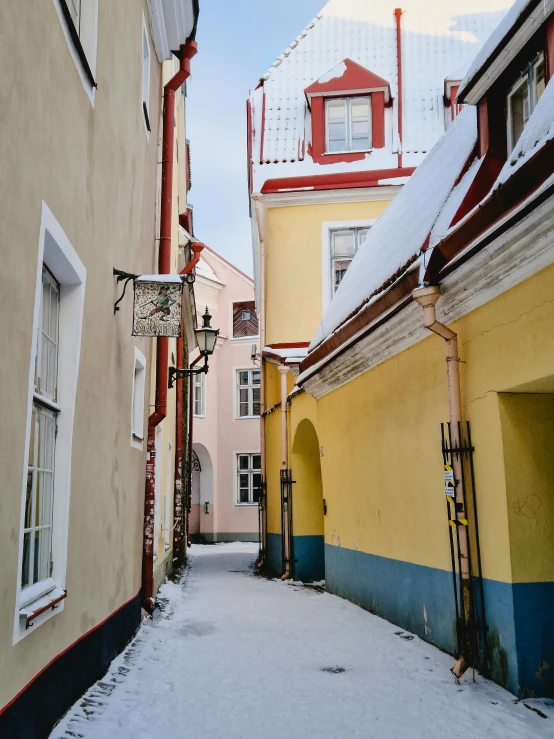 a street with several tall buildings and snow covered sidewalks