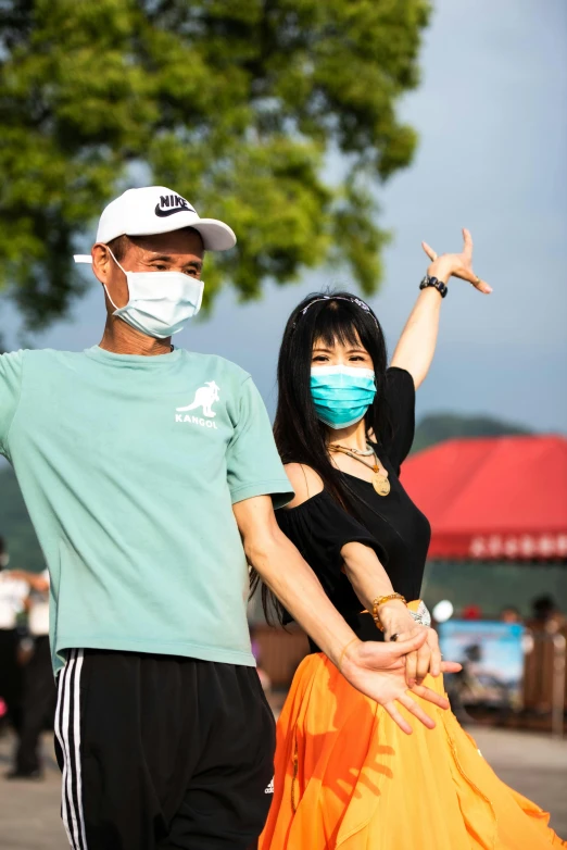 a man and woman wearing masks pose for a picture