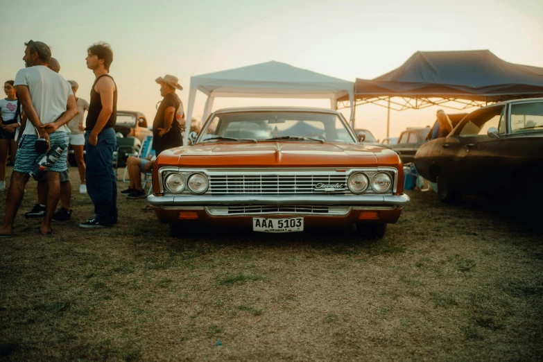 a car parked on the grass by a group of people