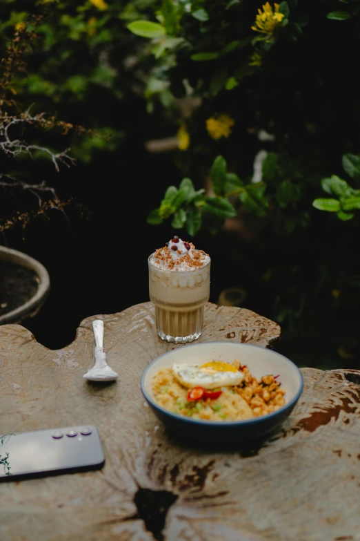 bowl of food on top of a rock near a plate of food