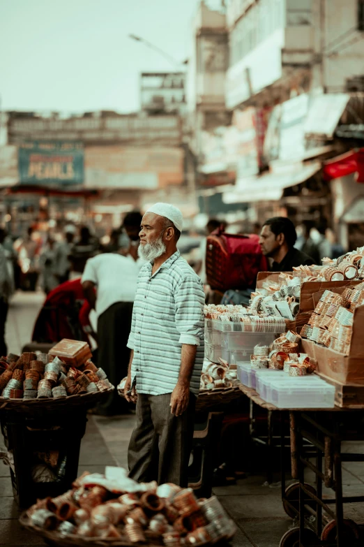 two men walk past a covered market with many containers full of food