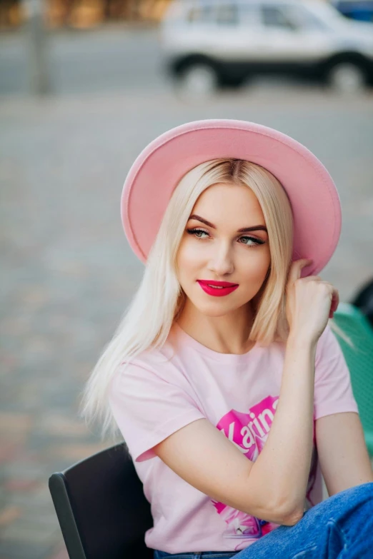 the blonde haired girl is wearing a pink hat