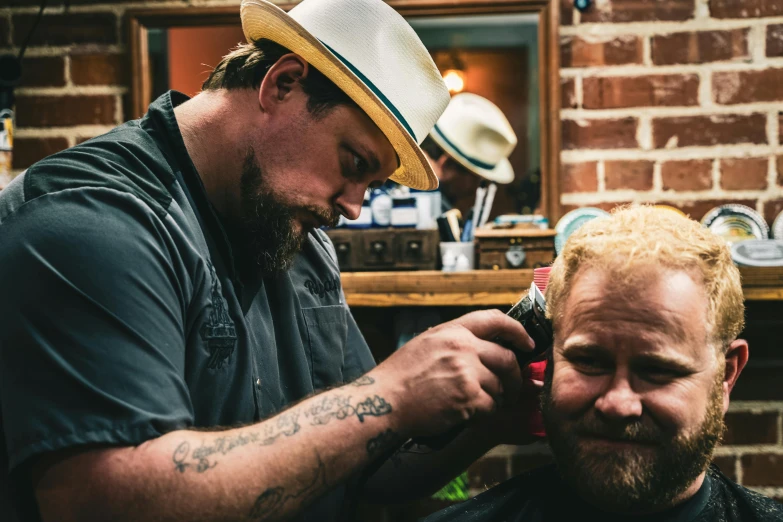 a man getting his hair cut by another person