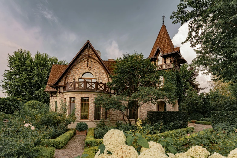 an old style home with flowers and bushes