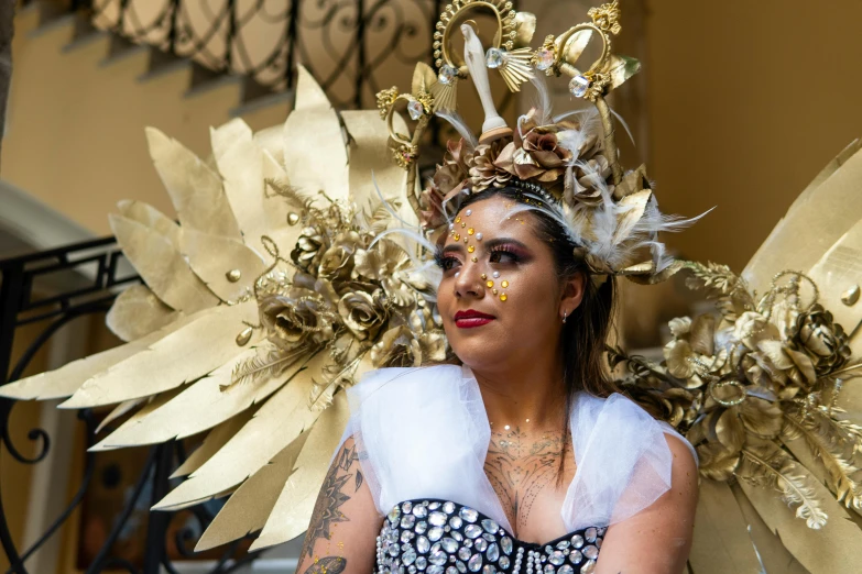 a woman with tattoos and wings is dressed in fancy costume