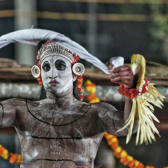 a painted man with his face and neck covered in decorations