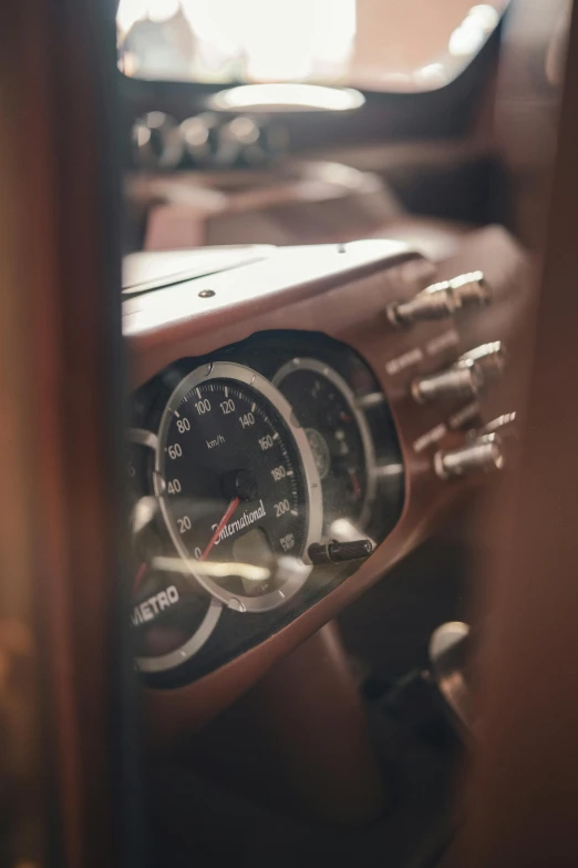 an older model dashboard and gauges are seen through the car's glass