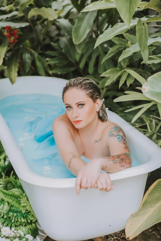 a woman is in a white bathtub outdoors