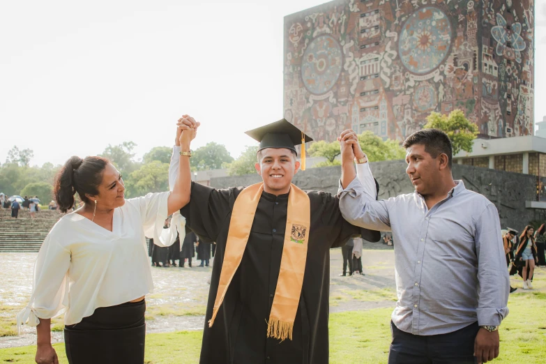 man in graduation outfit standing with other people