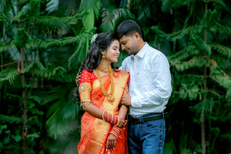 a man and woman in front of some trees