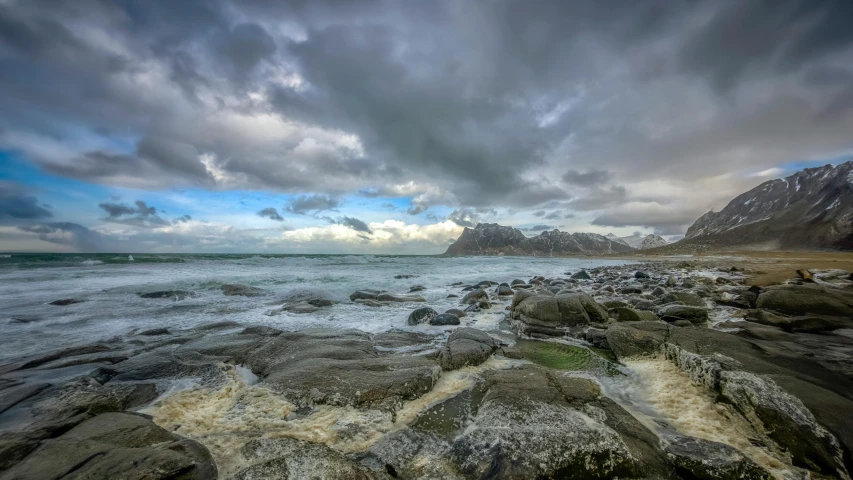 a landscape po with the ocean and mountains in the background