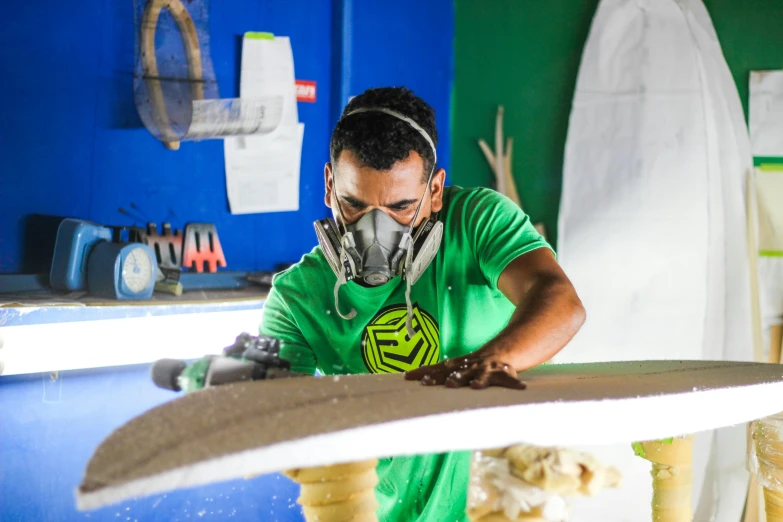 a man with an industrial mask on working on a large iron