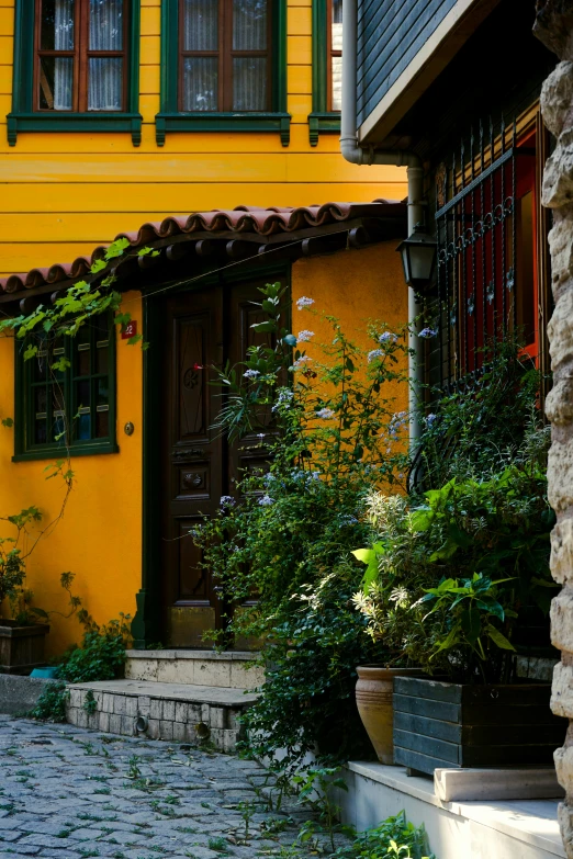 a yellow house with green trim and an ornate balcony