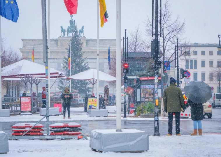 two people standing at an intersection with flags flying