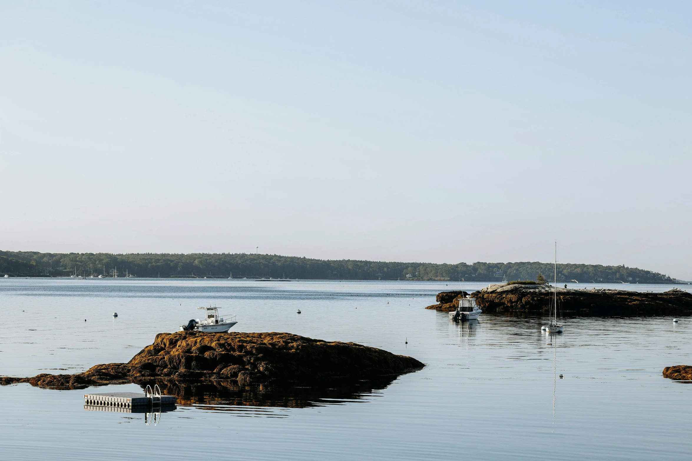 people standing on some rocks in the water