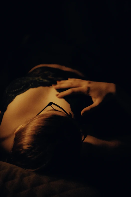 a woman laying in bed under a black lit light