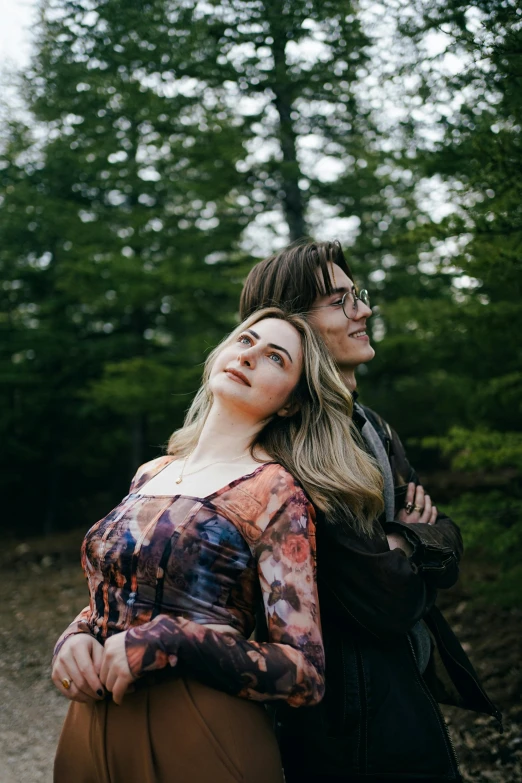 two beautiful women are looking up in the woods