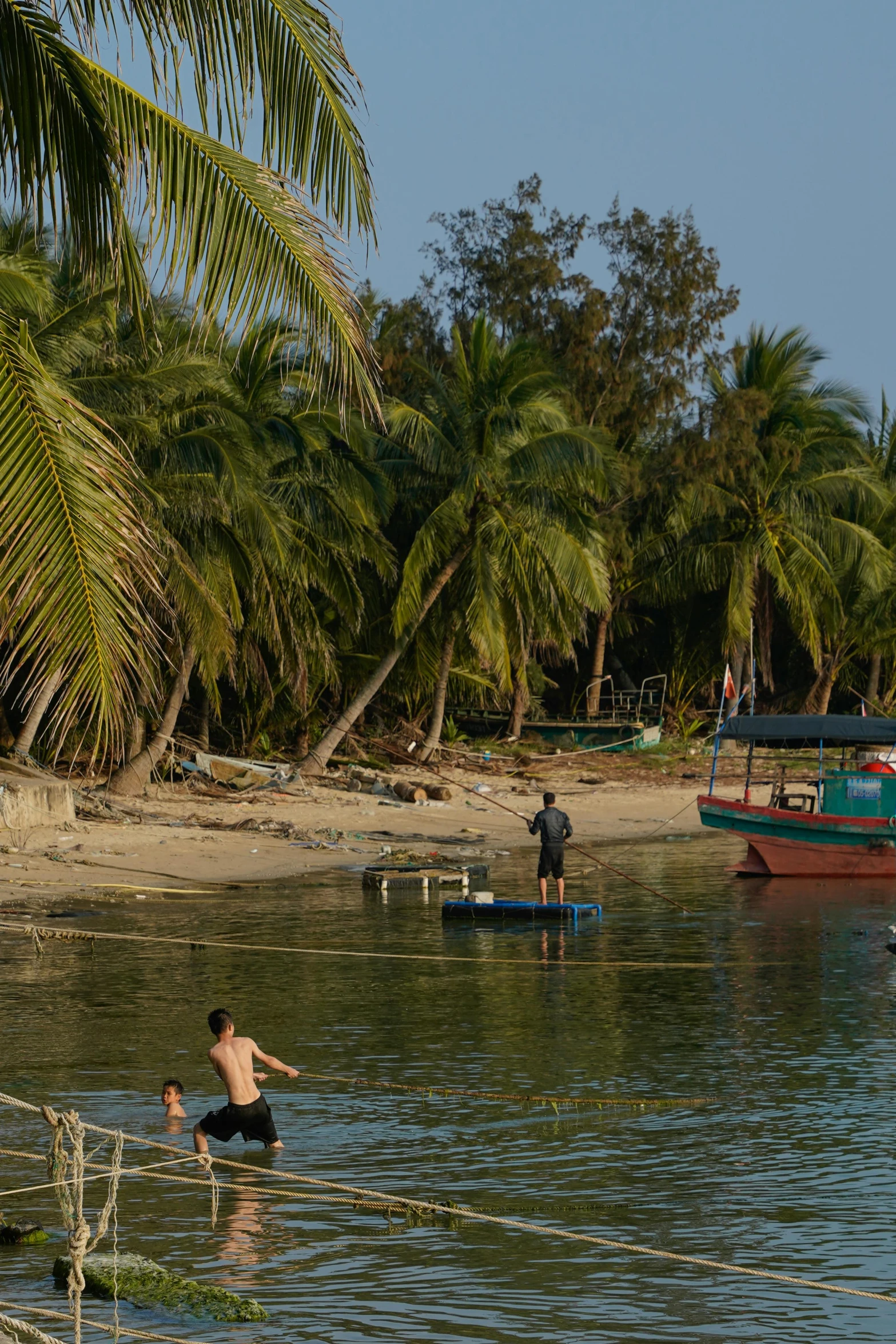 two men are playing with two small boats on a shore