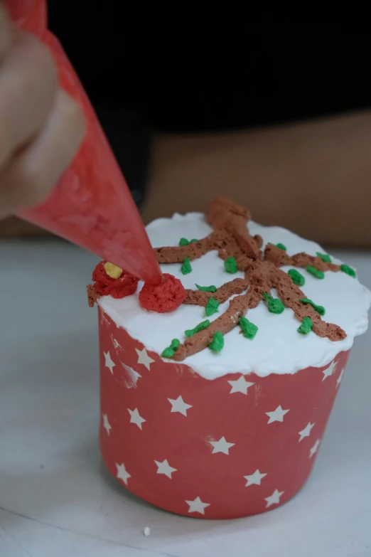 a cupcake with white icing and green decorations on top