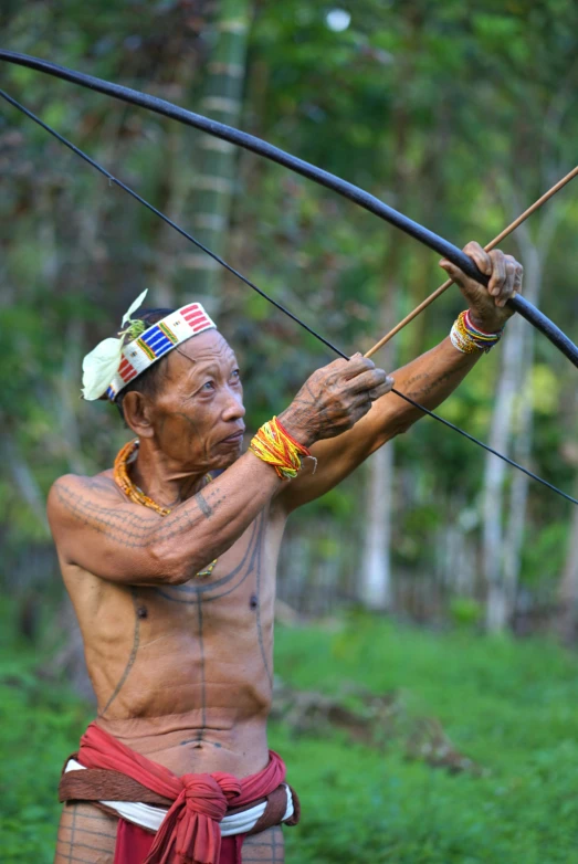 the man is holding a bow and arrows in his hands
