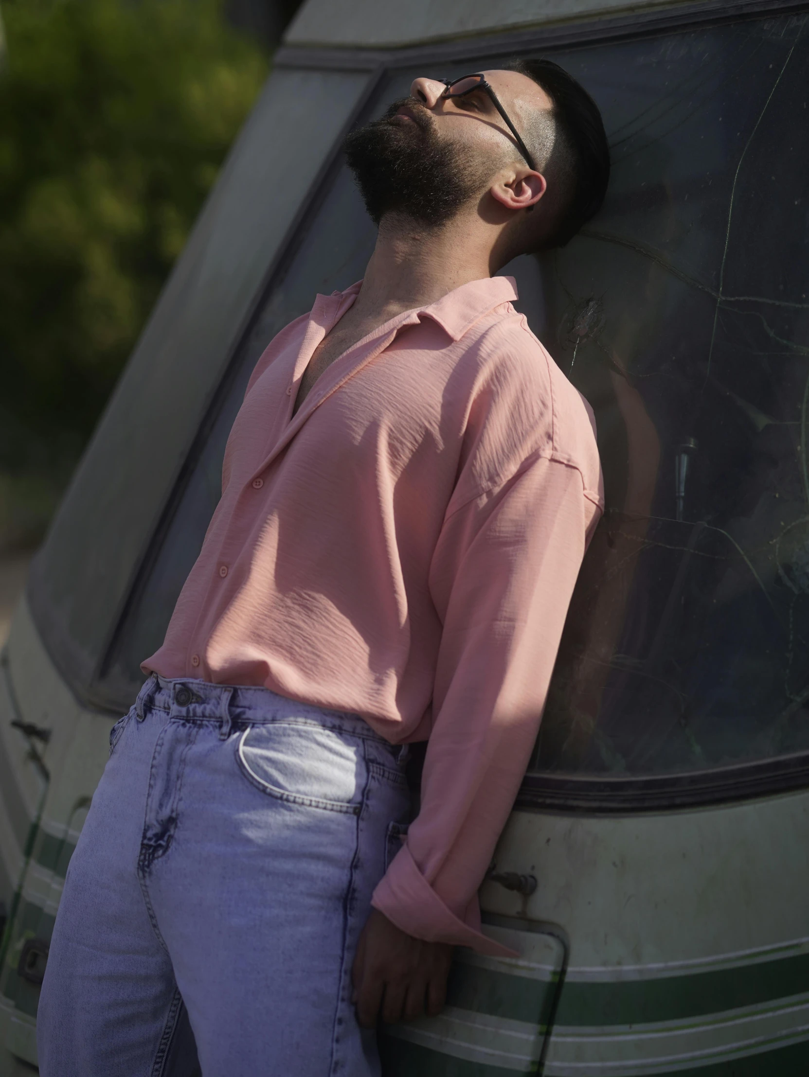 a man leaning against a bus window in a pink top