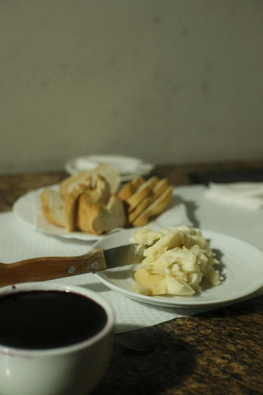 a spoon sits on a plate next to a plate with toast